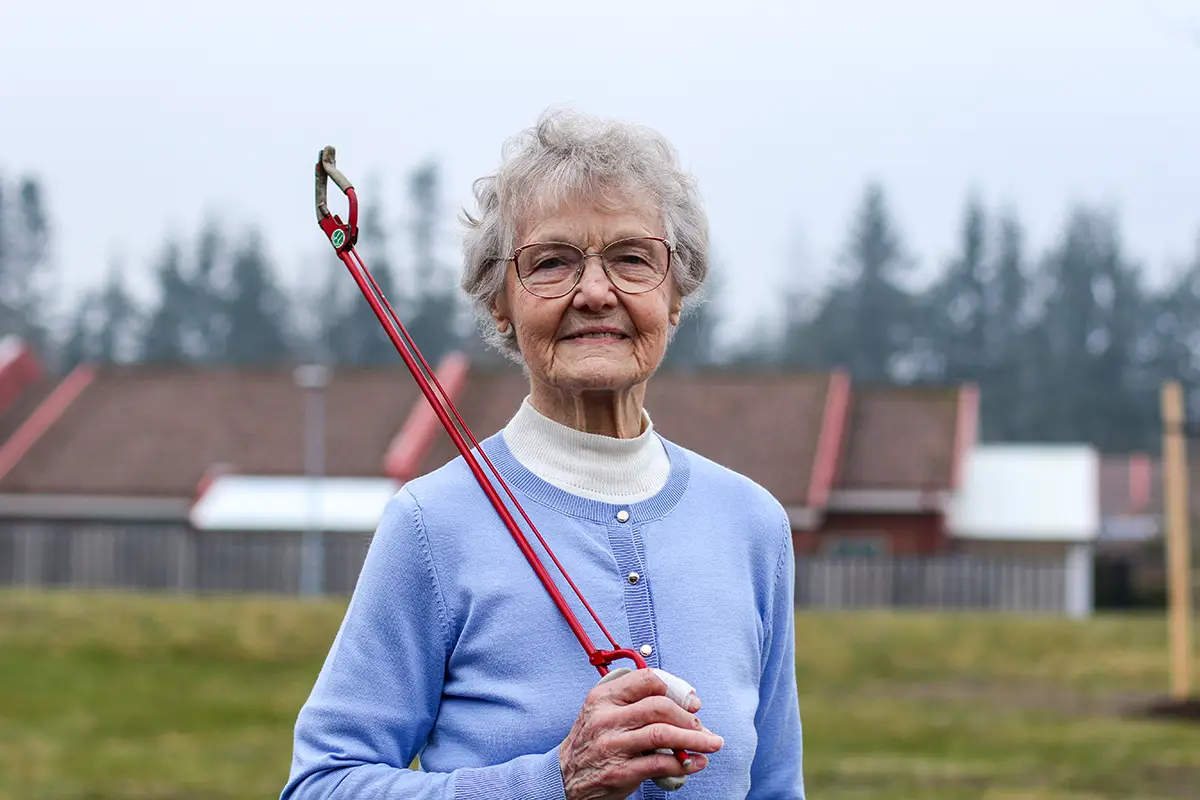 Birgit Rooth med sin röda skräpplockartång.